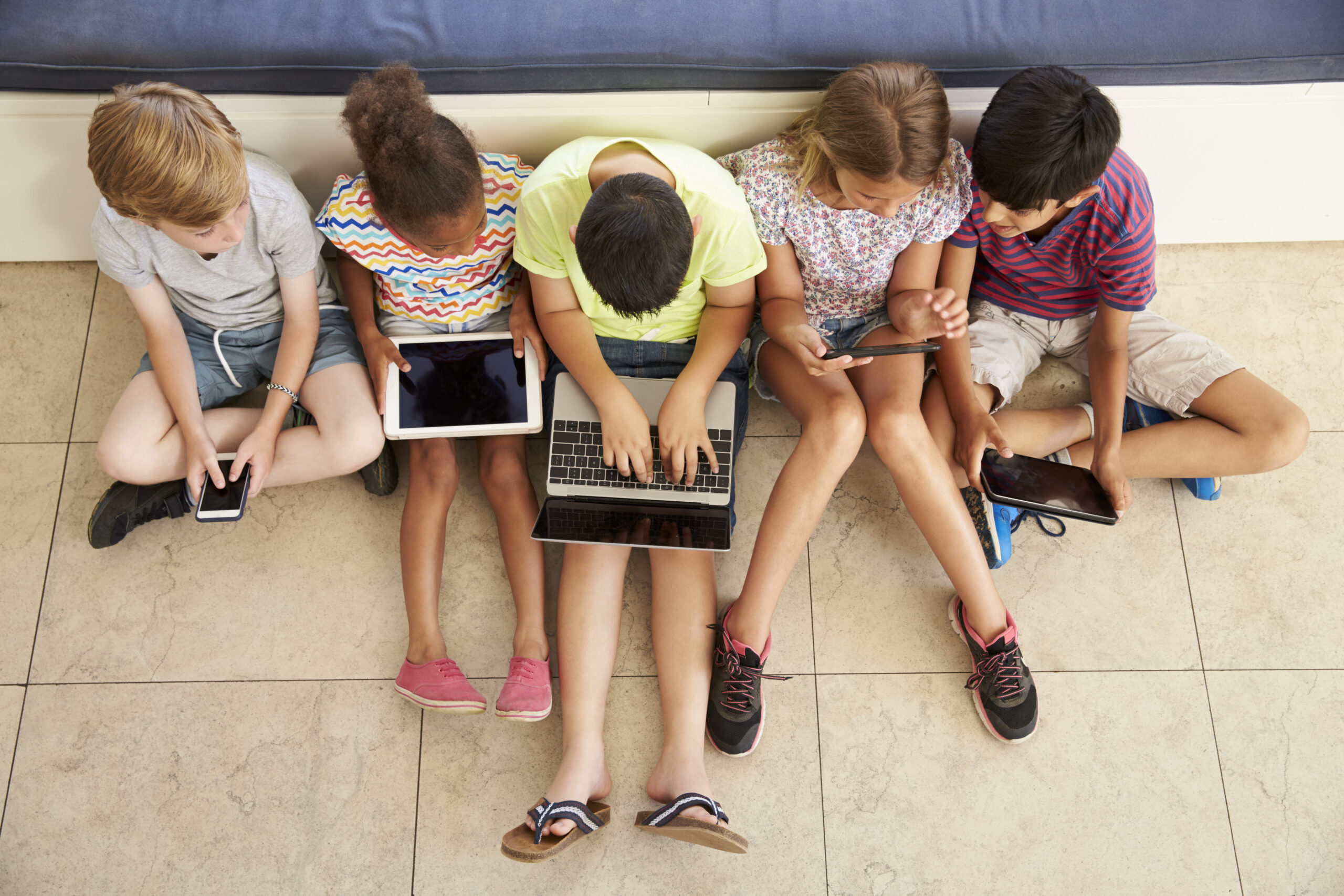 Overhead,Shot,Of,Children,Sitting,On,Floor,Using,Technology